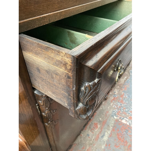 431 - An early 20th century carved oak sideboard