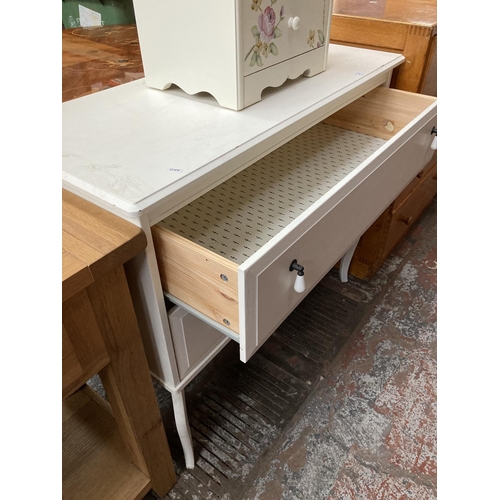 439 - Two items, a Dunelm Louisa hand painted cream three drawer bedside cabinet and a modern white chest ... 