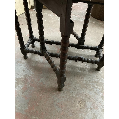 470 - An 18th century oak drop leaf gate leg dining table on barley twist supports