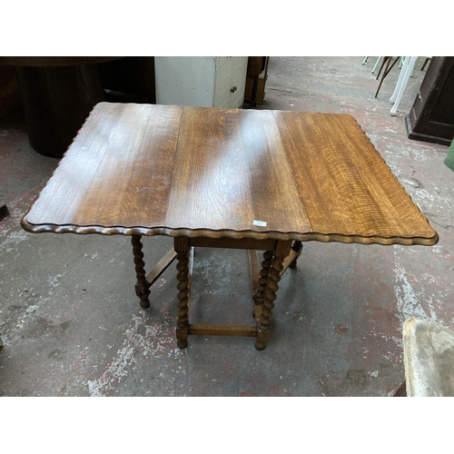 471 - An early 20th century oak drop leaf gate leg dining table on barley twist supports with pie crust ed... 