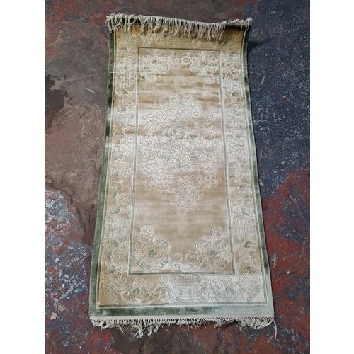 204B - A small Chinese silk rug - approx. 118cm long and 61cm wide