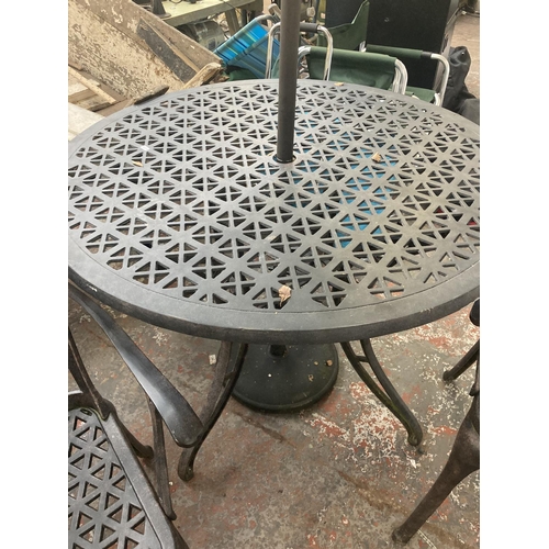 1127 - A four piece cast aluminium patio set comprising circular ornate table, two matching chairs, parasol... 