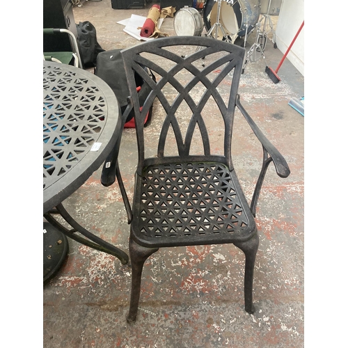 1127 - A four piece cast aluminium patio set comprising circular ornate table, two matching chairs, parasol... 