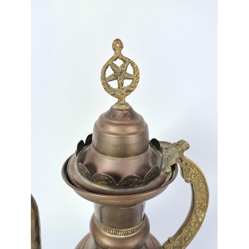 113 - Three pieces of brassware to include a pair of serpent candlesticks and a middle eastern coffee pot