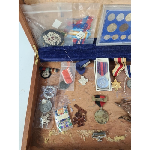 138 - A vintage wooden box containing various items to include eleven different circulated coins from Cypr... 