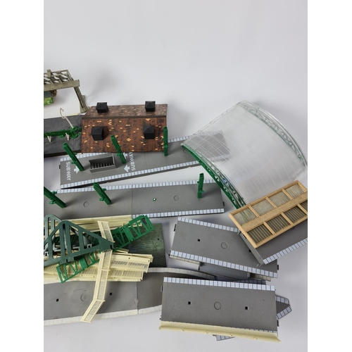 146 - A box containing OO gauge model railway accessories to include station parts, building footbridge et... 