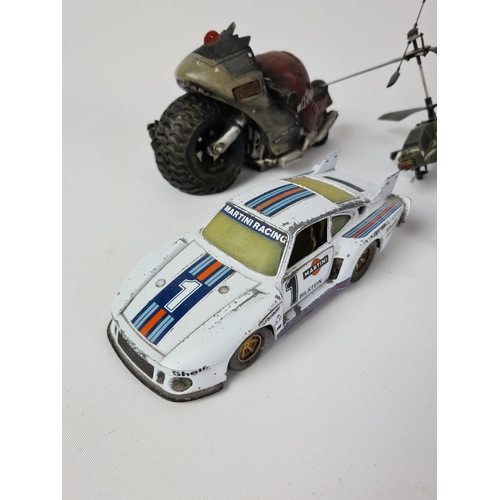 173 - A collection of various toys to include Burago Porsche 935 TT etc.