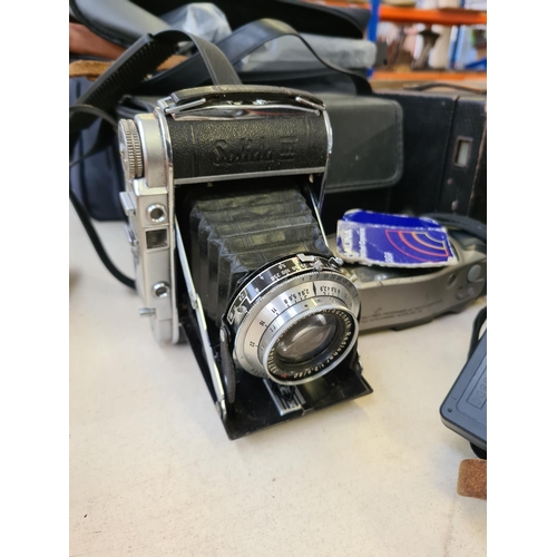 251 - A collection of various camera equipment and accessories to include a vintage Nettar film camera wit... 