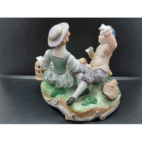 76 - A Dresden style porcelain group figurine of a young boy and girl with lamb and impressed marks to ba... 