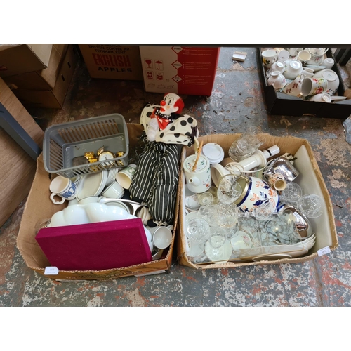 1275 - Two boxes containing miniature brass clocks, Steelite crockery, clown doll, Ford desk clock etc.