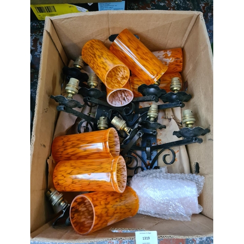 1319 - A box containing 1970s style metal and brass wall lights with orange glass shades