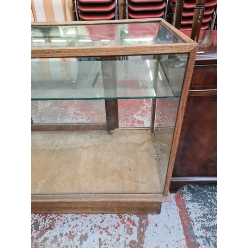 299 - An early/mid 20th century oak and glass shop display cabinet - approx. 137cm wide x 91cm high x 60cm... 