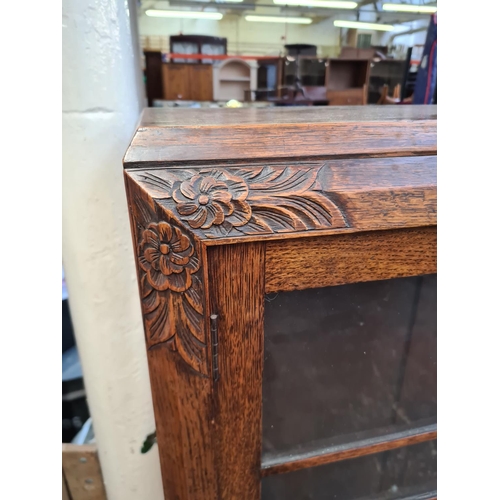 306 - An early 20th century carved oak bookcase - approx. 92cm wide x 132cm high x 30cm deep