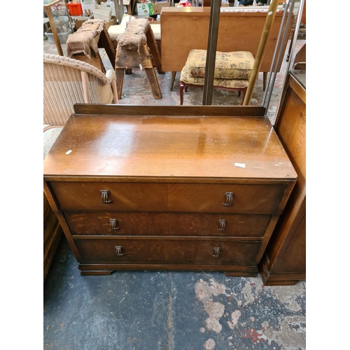 316 - A 1930s oak two piece bedroom suite comprising chest of drawers and cabinet