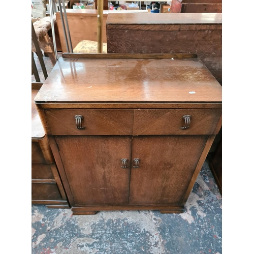 316 - A 1930s oak two piece bedroom suite comprising chest of drawers and cabinet