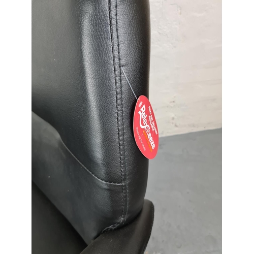 369 - A Relaxateeze black faux leather recliner swivel armchair with matching stool and original tags