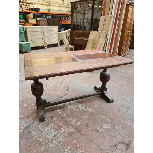 407 - An early 20th century oak extending rectangular dining table on baluster supports