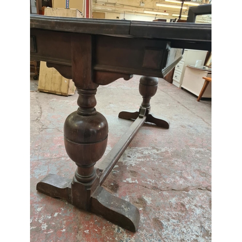 407 - An early 20th century oak extending rectangular dining table on baluster supports