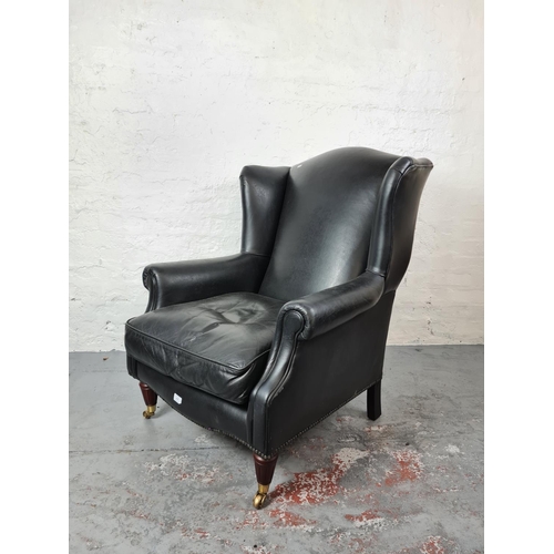 409 - An antique style black leather wing back arm chair