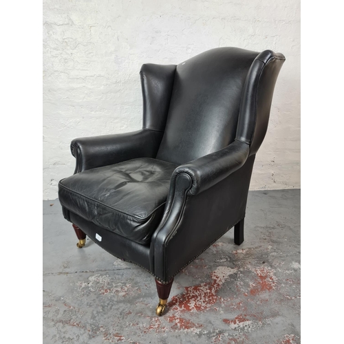 409 - An antique style black leather wing back arm chair