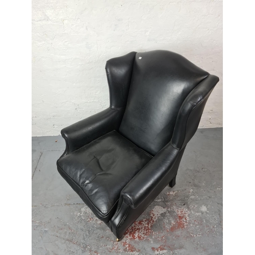 409 - An antique style black leather wing back arm chair