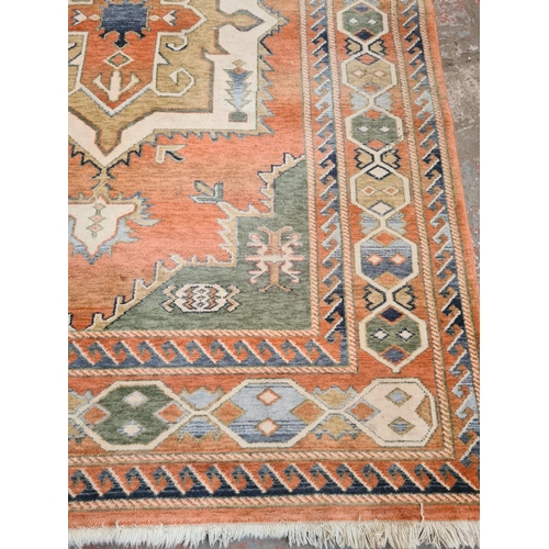 449 - A large vintage style rug with orange, green and blue tones