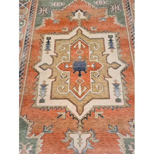 449 - A large vintage style rug with orange, green and blue tones