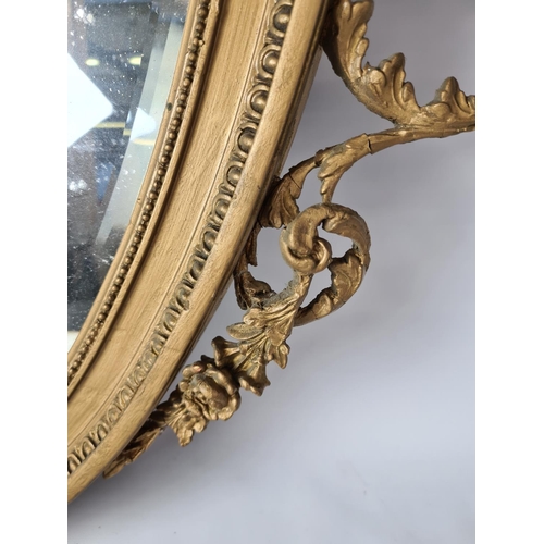 285 - A Regency gilt frame bevelled edge oval wall mirror with floral and urn swag top - approx. 92cm wide... 