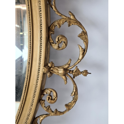 285 - A Regency gilt frame bevelled edge oval wall mirror with floral and urn swag top - approx. 92cm wide... 