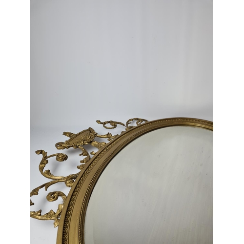 285 - A Regency gilt frame bevelled edge oval wall mirror with floral and urn swag top - approx. 92cm wide... 