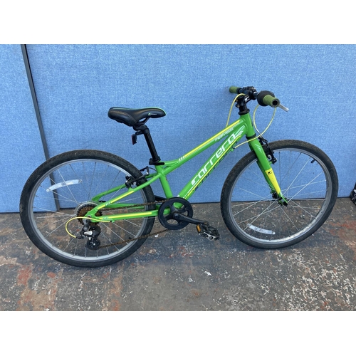 A green Carrera Abyss stunt bike with quick release wheels Tektro brakes and 7 speed Shimano Altus