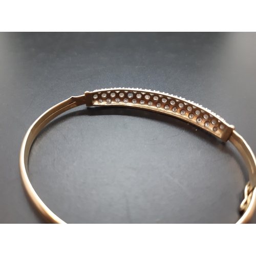 34 - A hallmarked 9ct gold ladies bangle with inset CZ stones - approx. total weight 6.29 grams