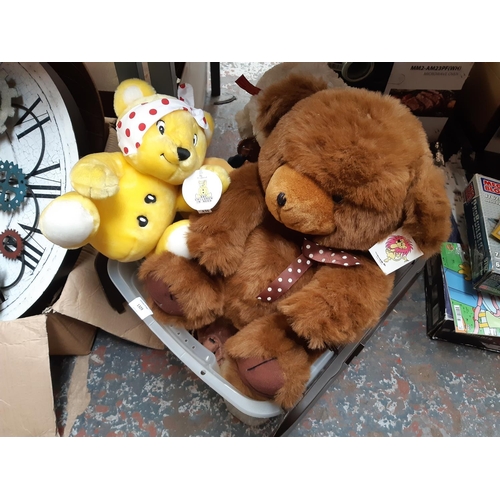 1329 - A large box of soft toys to include Sooty, Yogi Bear, Pudsey Bear etc.