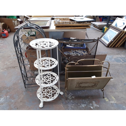 1351 - Four items to include fire guard, cast iron pan stand, wine rack and brass magazine rack