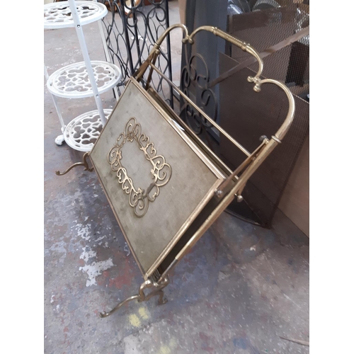 1351 - Four items to include fire guard, cast iron pan stand, wine rack and brass magazine rack