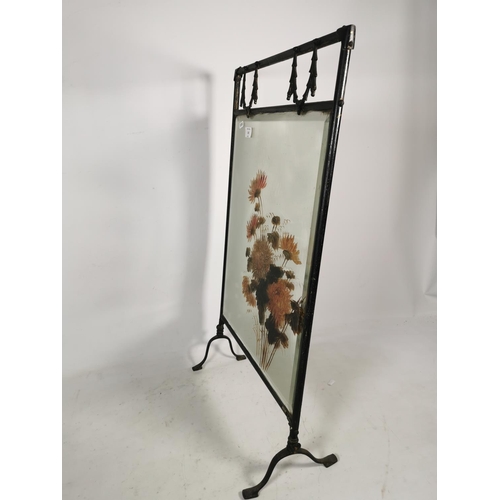 321 - A vintage black metal framed fireguard with hand painted bevelled mirror insert