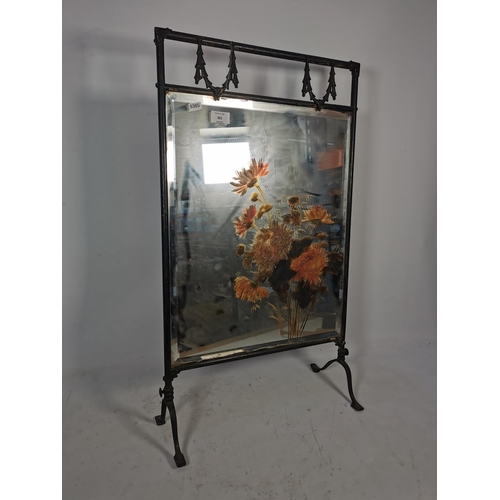 321 - A vintage black metal framed fireguard with hand painted bevelled mirror insert