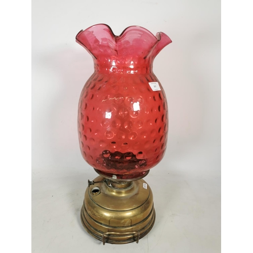 357 - A Veritas brass oil lamp with cranberry glass shade - approx. 55cm high