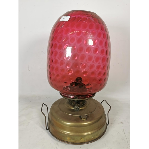 359 - A brass oil lamp with cranberry glass shade - approx. 49cm high