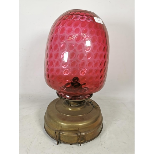 359 - A brass oil lamp with cranberry glass shade - approx. 49cm high