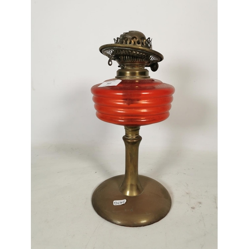 362 - A British made brass oil lamp with red glass reservoir - approx. 33cm high