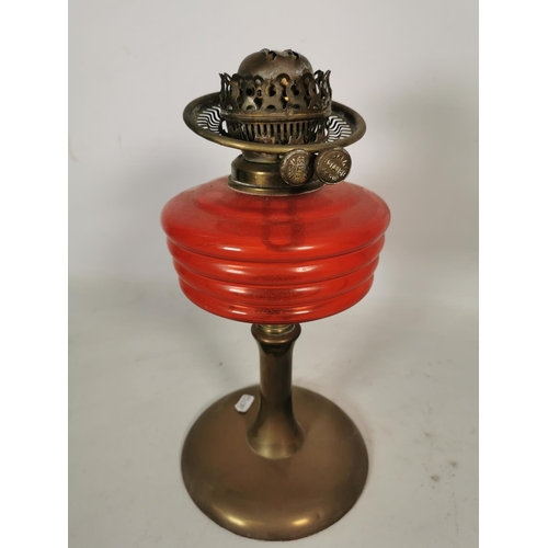 362 - A British made brass oil lamp with red glass reservoir - approx. 33cm high