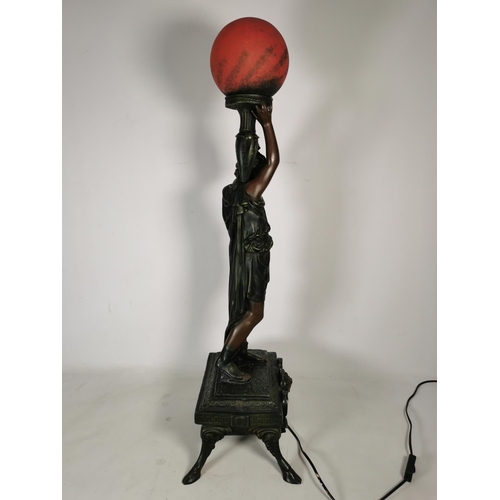 365 - An Art Nouveau style resin bronze effect sculptural table lamp with red glass spherical shade in the... 