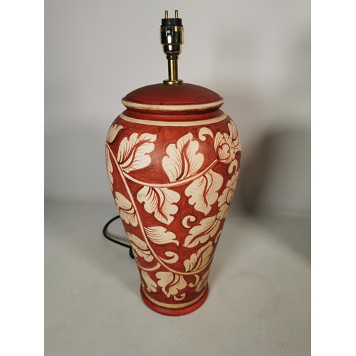 366 - A pair of Aimbry red painted ceramic table lamps with floral design - approx. 44cm high without bulb