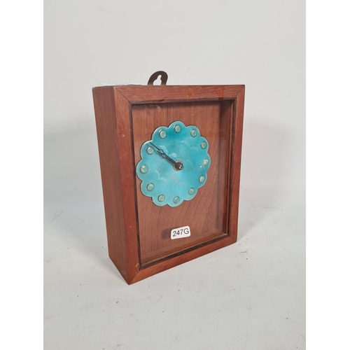 395 - A vintage teak cased wall clock with turquoise enamel face and bird design - approx. 21cm high x 16c... 