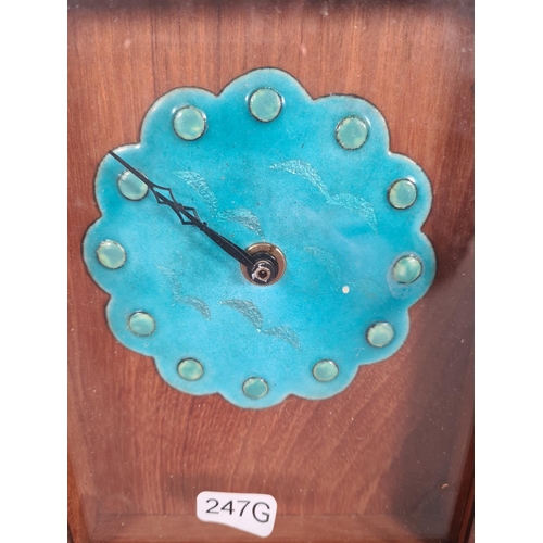 395 - A vintage teak cased wall clock with turquoise enamel face and bird design - approx. 21cm high x 16c... 