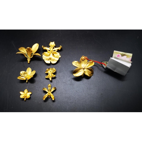 111 - A collection of gold plated jewellery to include two Risis of Singapore 22ct gold plated orchid broo... 