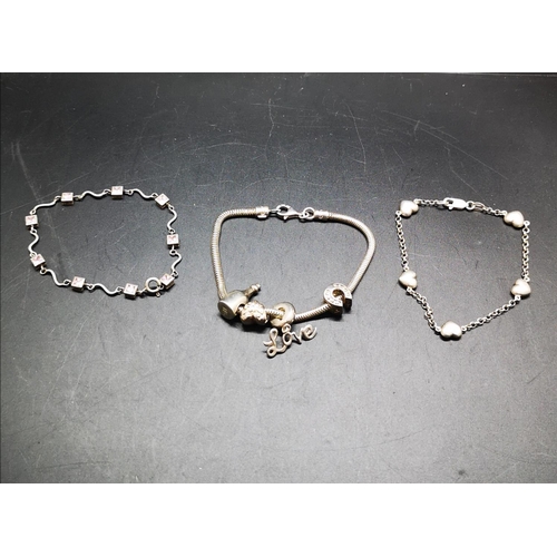 124 - Three various 925 silver bracelets to include one with 925 silver charms - approx. combined gross we... 