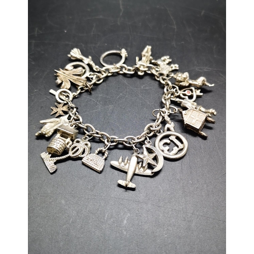 127 - A white metal charm bracelet with various charms - approx. gross weight 52 grams
