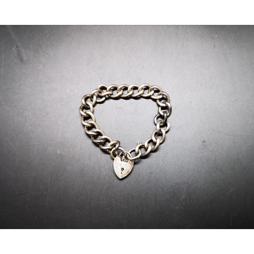 132 - A hallmarked London silver charm bracelet with heart shaped padlock charm - approx gross weight 39.2... 